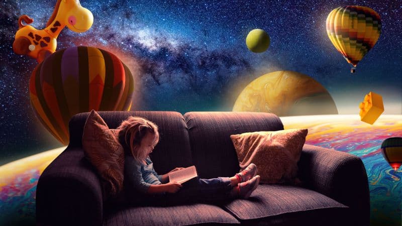 Cute Girl Reading book on Couch Wallpaper