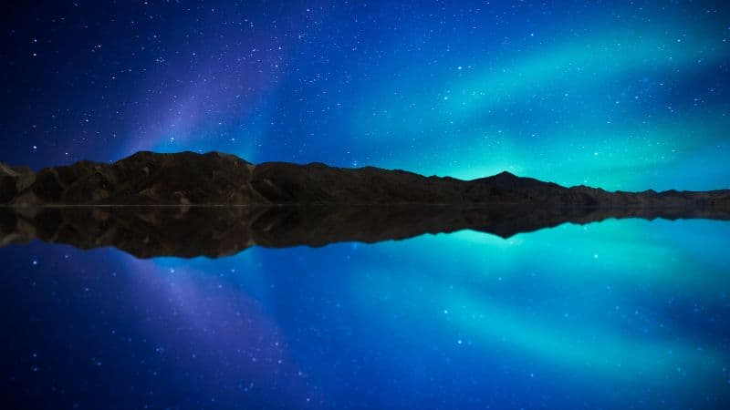 Aurora borealis reflected in the water of a lake Wallpaper