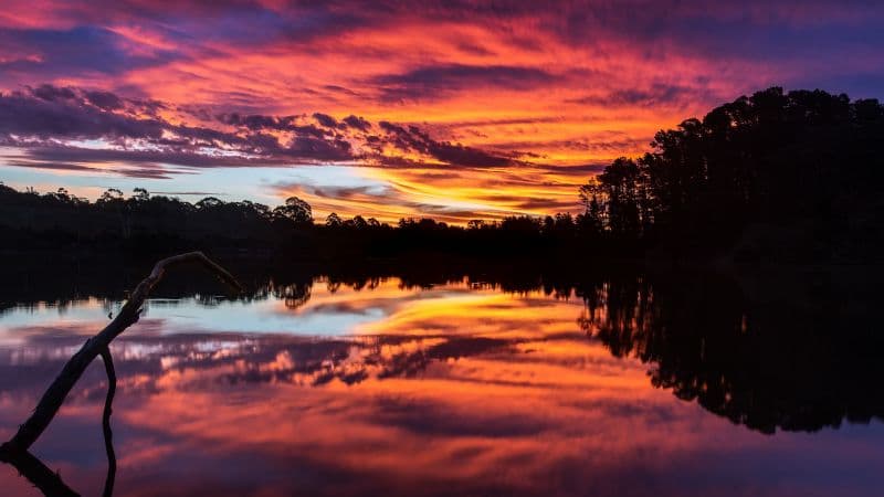 Sunset over a lake with trees Wallpaper